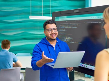 Mann mit Laptop Mann mit Laptop und blonde Frau reden miteinander