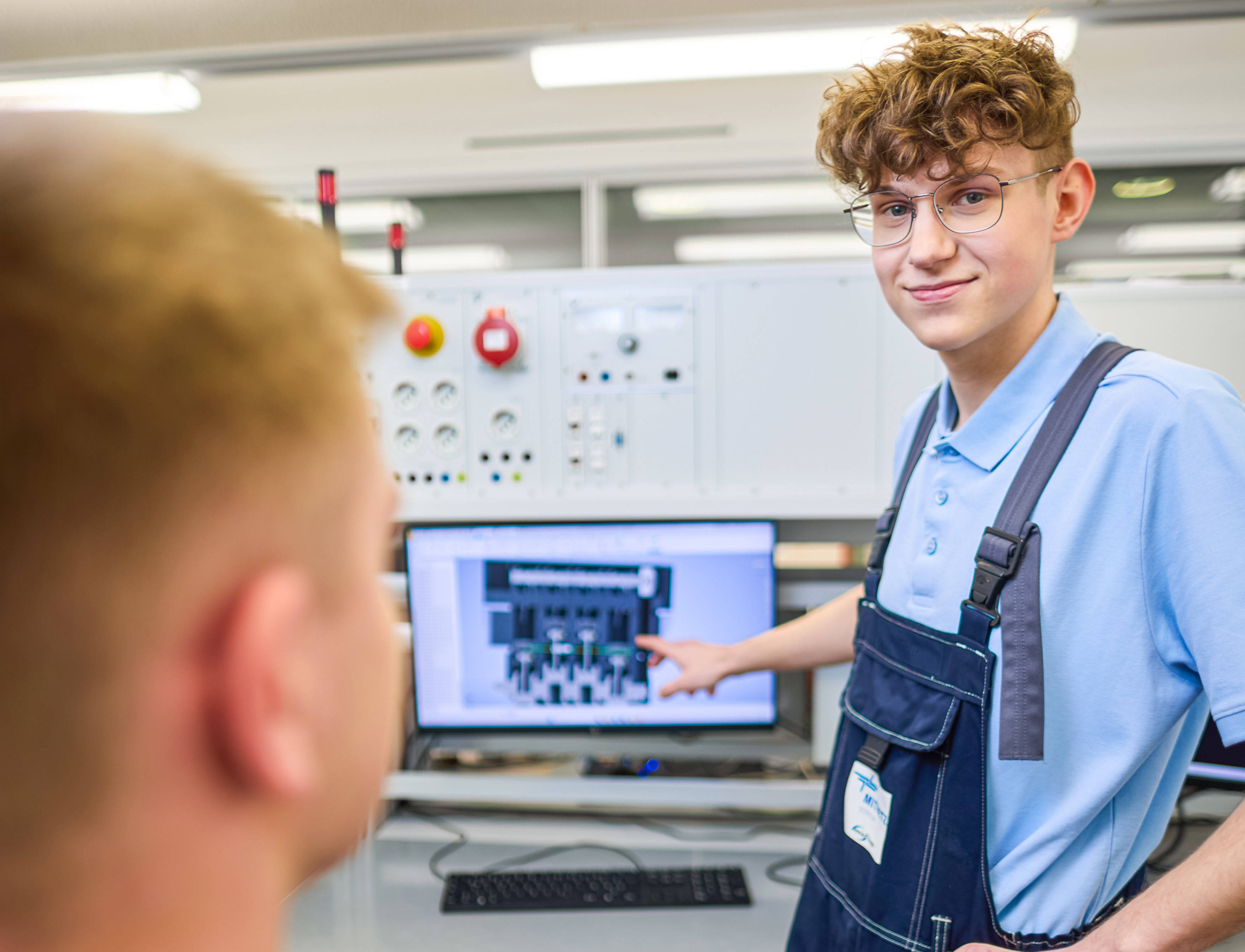ein Auszubildender zeigt etwas an einem Monitor
