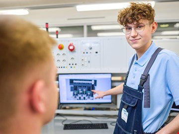 mann-pc ein Auszubildender zeigt etwas an einem Monitor